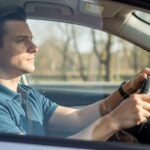 Driver demonstrating proper 9 and 3 hand position on steering wheel for optimal vehicle control