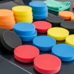 Assorted foam polishing pads in different colors arranged on a car hood for detailing