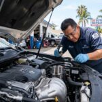Mechanic inspecting a power steering pump inside a car engine bay in San Diego